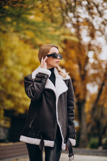 Mujer joven, llevando, chaqueta, ambulante, exterior