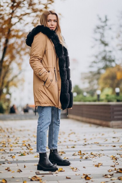 Mujer joven, llevando, chaqueta, ambulante, exterior