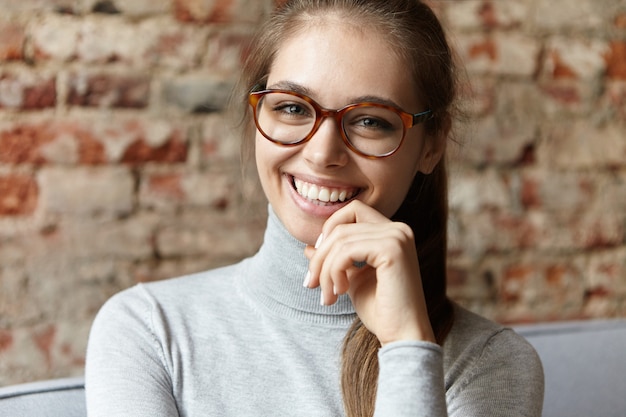 Mujer joven, llevando, gris, cuello alto, y, anteojos