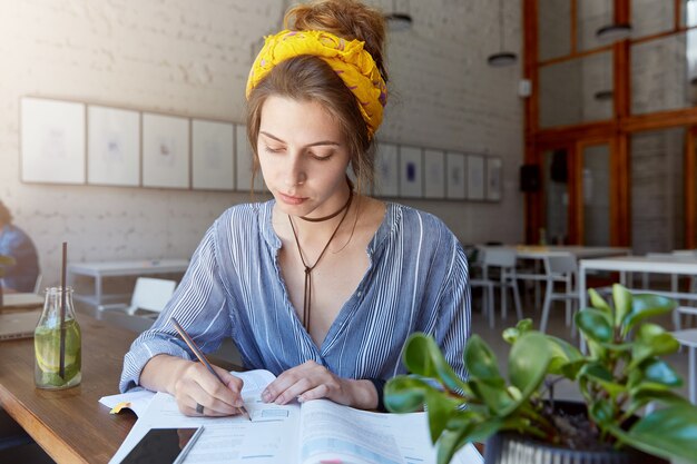 Mujer joven, llevando, pañuelo, y, estudiar, en, café