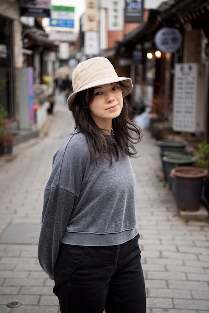 Mujer joven, llevando, un, sombrero del cubo, en la ciudad