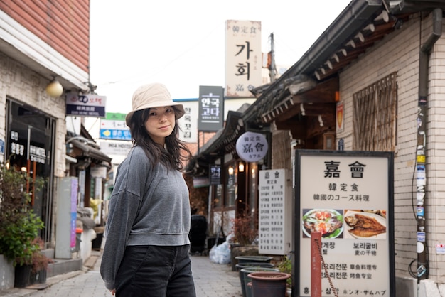 Foto gratuita mujer joven, llevando, un, sombrero del cubo, en la ciudad