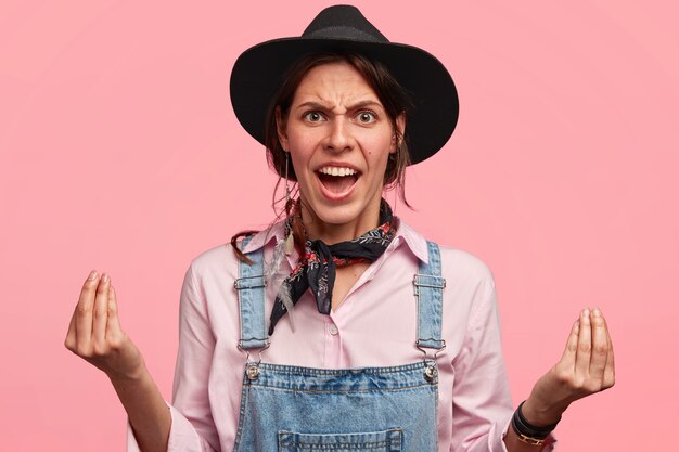 Mujer joven, llevando, sombrero grande, y, overol de mezclilla