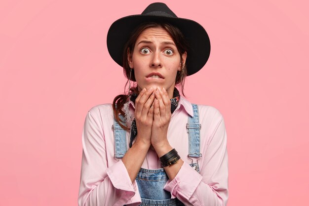 Mujer joven, llevando, sombrero grande, y, overol de mezclilla