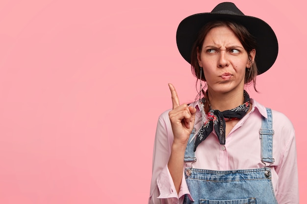 Mujer joven, llevando, sombrero grande, y, overol de mezclilla