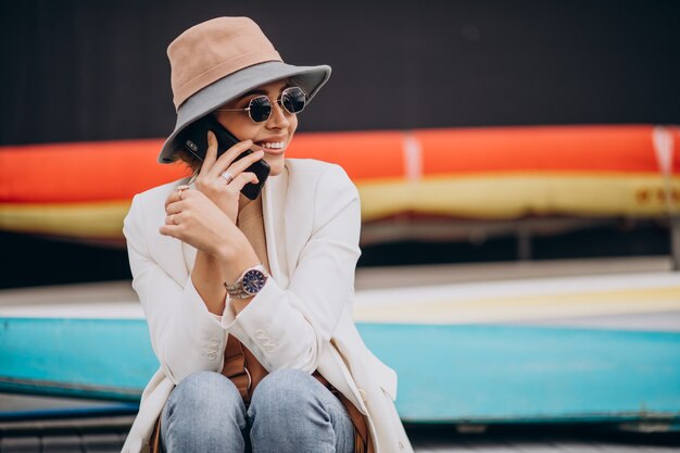 Mujer joven, llevando, sombrero, y, utilizar, teléfono