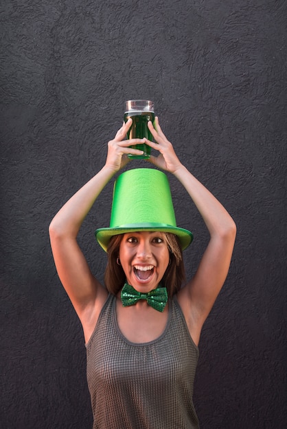 Foto gratuita mujer joven llorando en el sombrero de san patricio con vaso de bebida