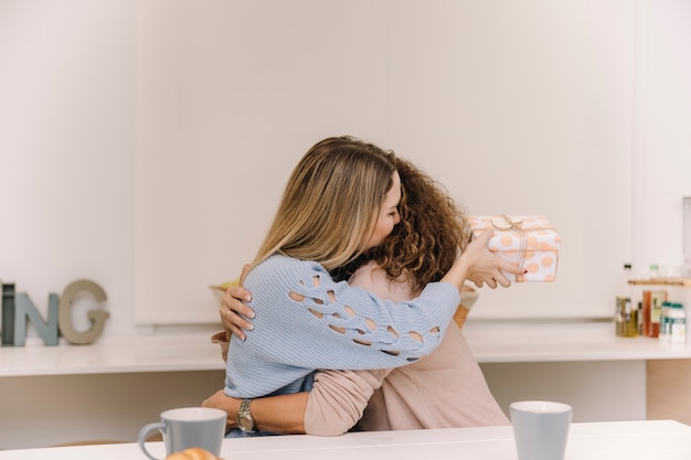 Foto gratuita mujer joven con la madre abrazando presente