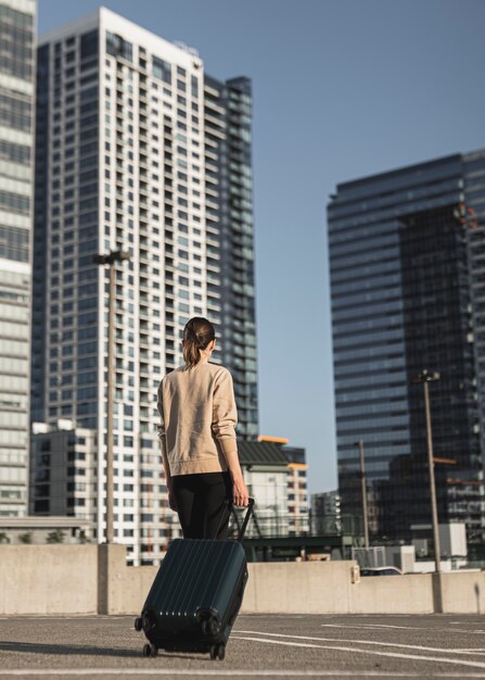 Mujer joven con una maleta en la ciudad