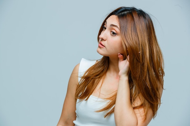 Mujer joven, manos de valor en cartera, atrás, oreja