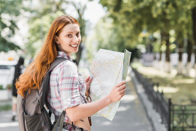 Mujer joven con mapa en el parque