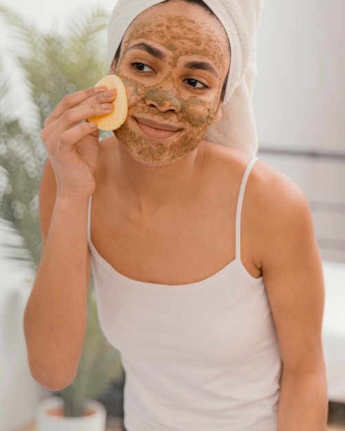 Foto gratuita mujer joven con una máscara casera en su rostro