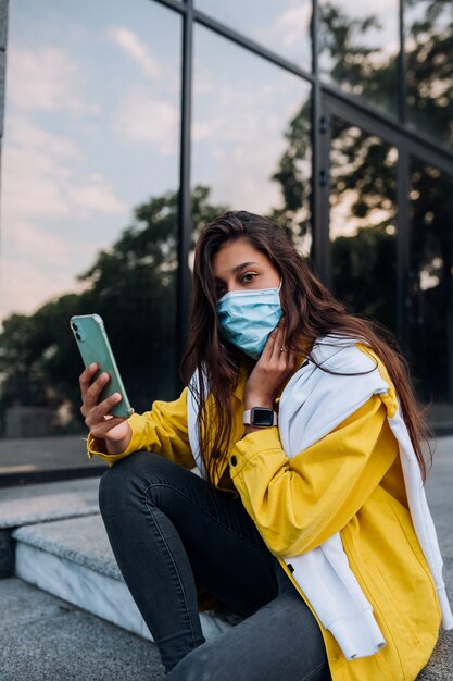 Mujer joven con máscara posando en la calle.