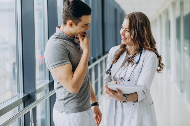 Mujer joven médico practicante consulta paciente masculino