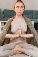 Foto gratuita mujer joven meditando en casa