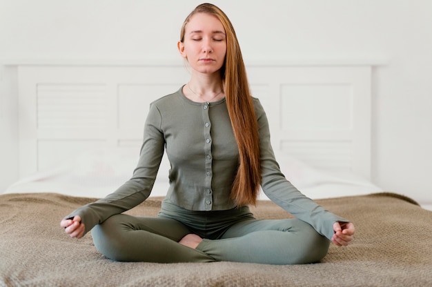 Foto gratuita mujer joven meditando en casa