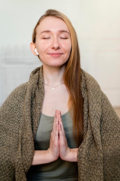 Foto gratuita mujer joven meditando en casa