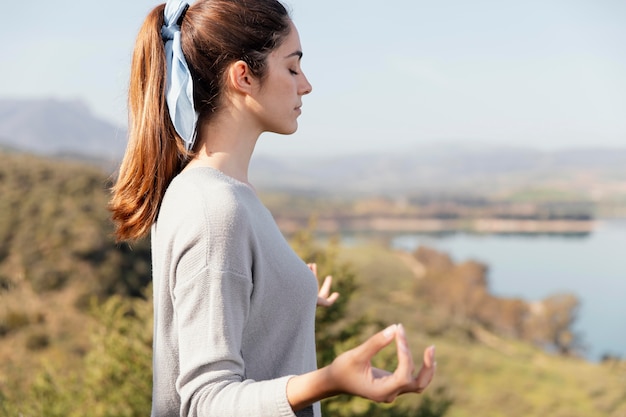 Mujer joven meditando en la naturaleza