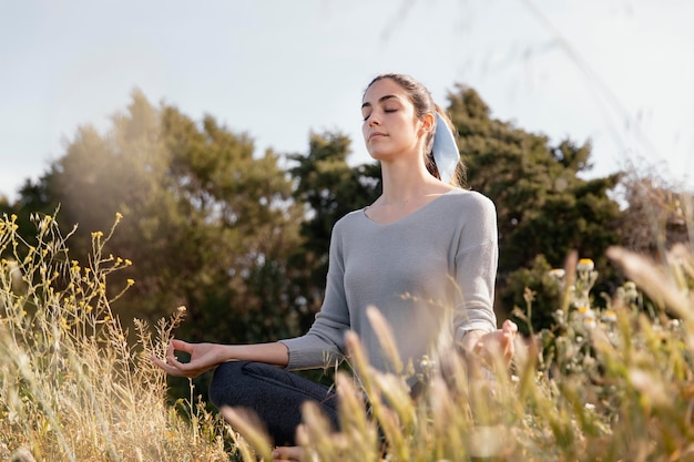 Mujer joven meditando en la naturaleza