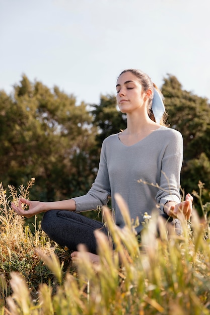 Mujer joven meditando en la naturaleza