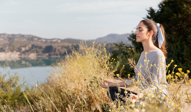 Foto gratuita mujer joven meditando en la naturaleza