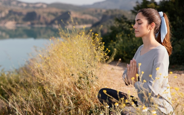 Mujer joven meditando en la naturaleza