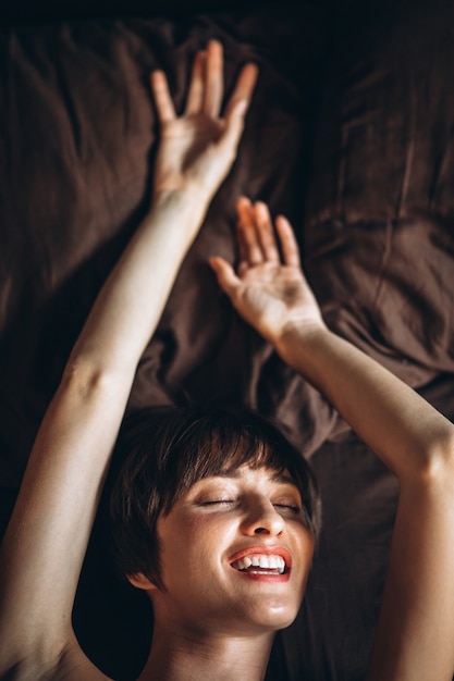 Mujer joven, mentira en cama, por la mañana