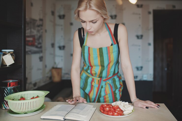 Foto gratuito mujer joven mirando hacia arriba en un libro de recetas