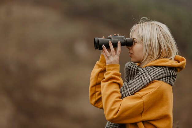 Mujer joven mirando con binoculares