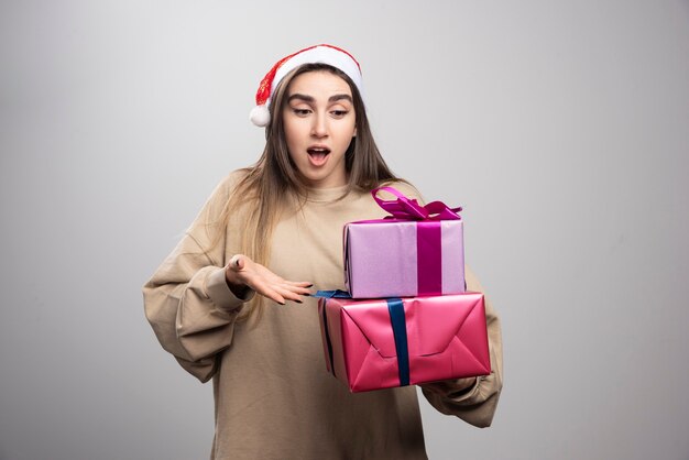 Mujer joven mirando dos cajas de regalos de Navidad.