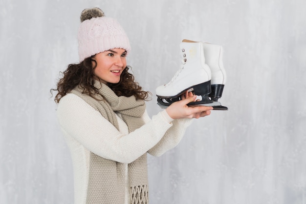 Mujer joven mirando patines de hielo