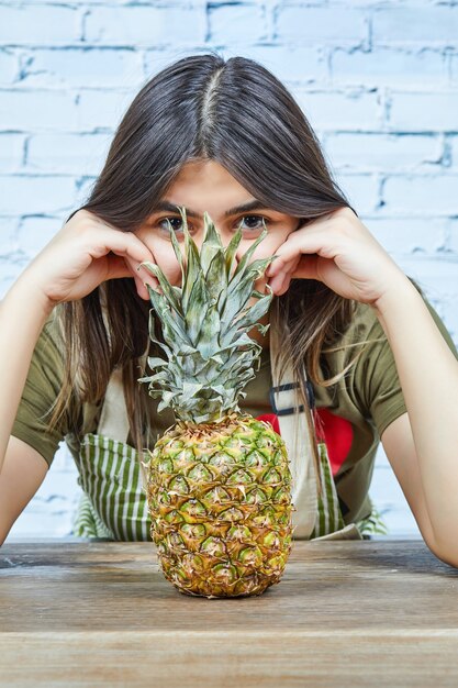 Mujer joven mirando la piña.