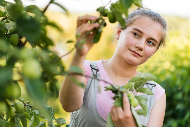 Mujer joven mirando ramas de los árboles