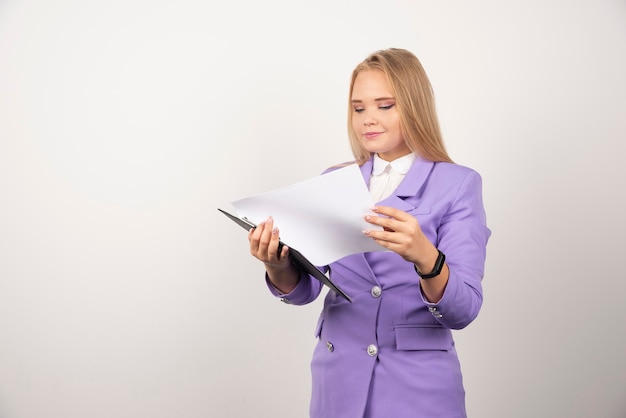 Foto gratuita mujer joven mirando tableta en blanco.