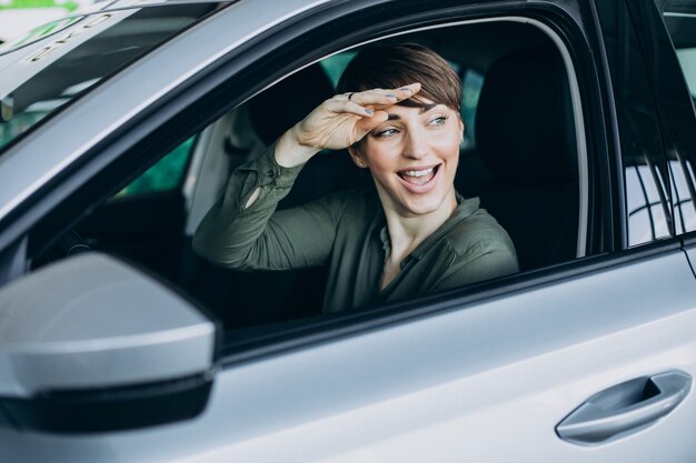 Mujer joven mirando por la ventana del coche