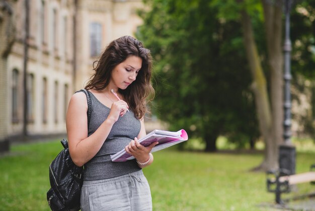 Mujer joven con mochila y libros