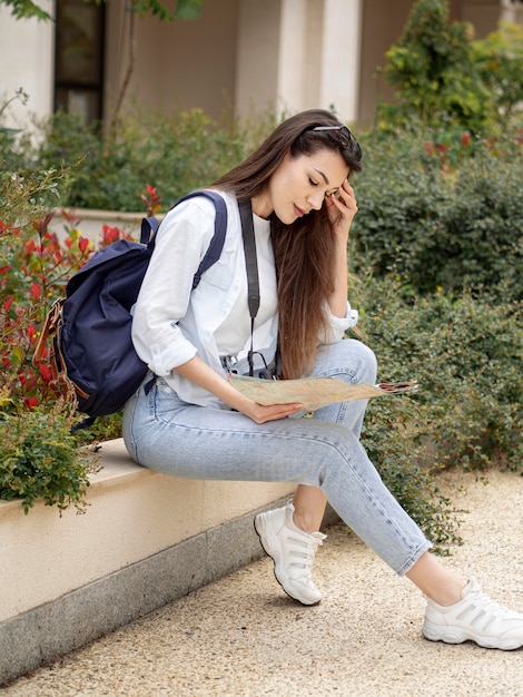 Mujer joven con mochila y mapa