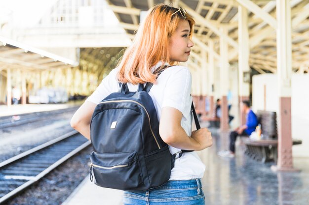 Mujer joven con mochila en plataforma