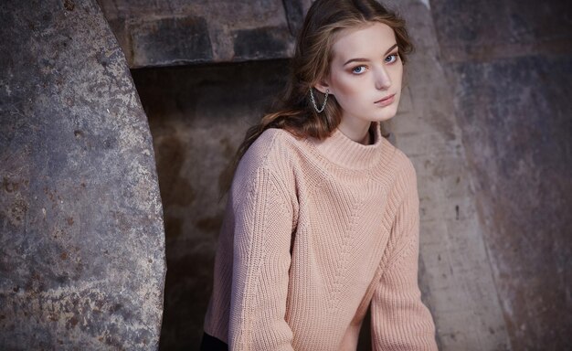 Mujer joven de moda en un jersey color crema.