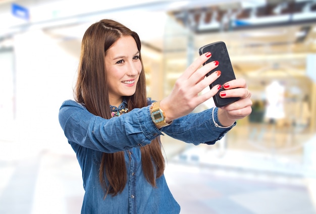 mujer joven de moda que usa un teléfono inteligente para tomar una foto
