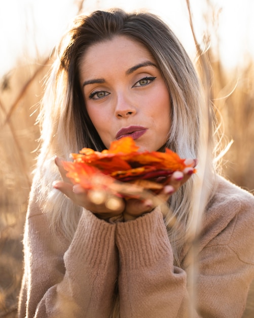 Foto gratuita mujer joven moderna que sostiene la taza de café que se sienta en el sofá que mira la cámara