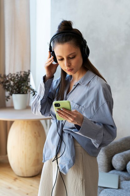Mujer joven con moño desordenado escuchando música