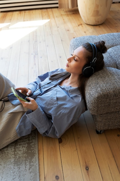 Mujer joven con moño desordenado escuchando música