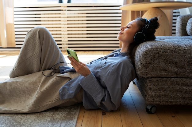 Mujer joven con moño desordenado escuchando música