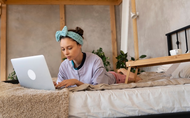 Foto gratuita mujer joven con moño desordenado trabajando desde casa