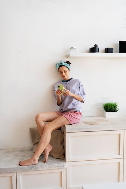 Foto gratuita mujer joven con moño desordenado trabajando desde casa