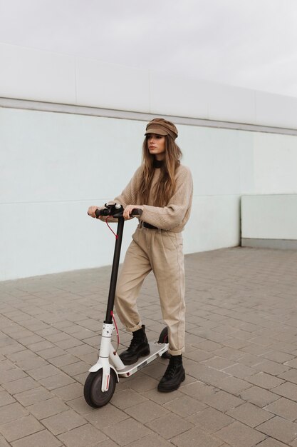 Mujer joven montando un scooter eléctrico