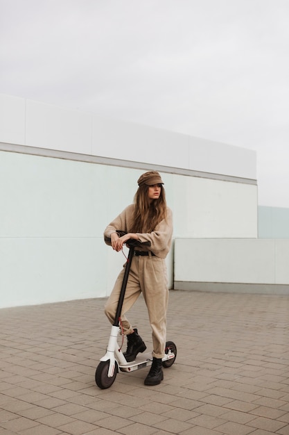 Foto gratuita mujer joven montando un scooter eléctrico