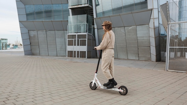 Mujer joven montando un scooter eléctrico