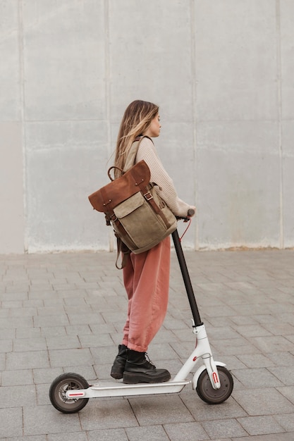 Mujer joven montando un scooter eléctrico